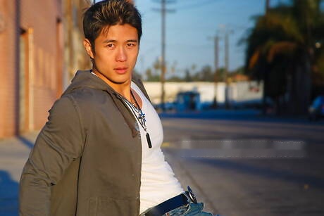 El fuerte toro asiático Peter Le se quita la ropa afuera