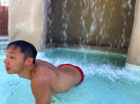 El joven oriental Dane Jaxson se masturba con un consolador en la piscina