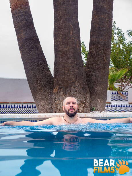スイスの熊アダム・ジョーンズがプールで裸になり、セクシーなお尻を見せる