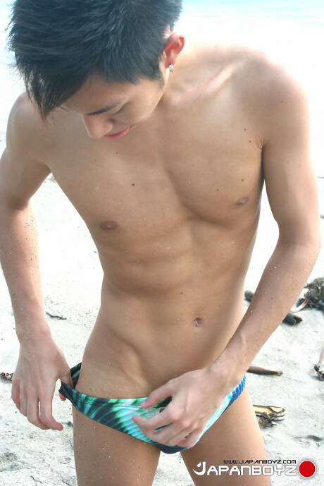 O jovem asiático Leo Ota posa nu após uma caminhada na praia