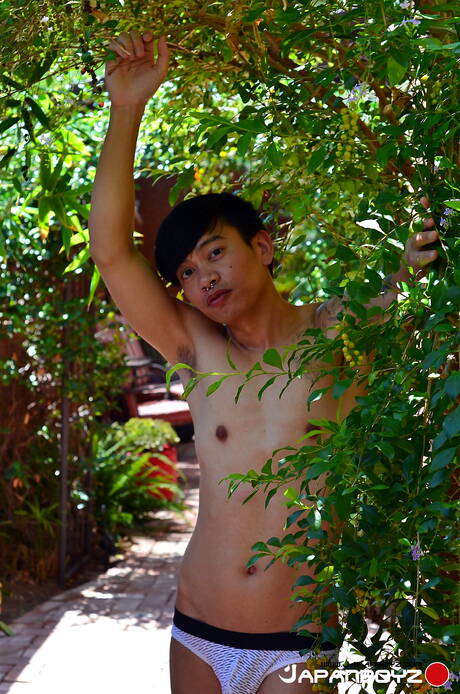 O lindo garoto oriental Chonna posando nu ao ar livre