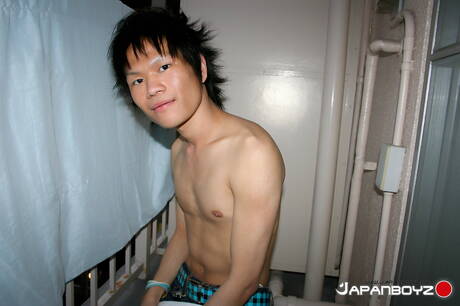 El jovencito oriental Masaru Sato se divierte con un juguete en el baño