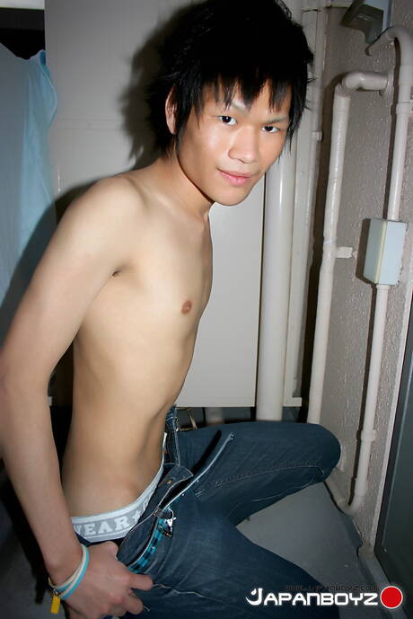 El jovencito oriental Masaru Sato se divierte con un juguete en el baño