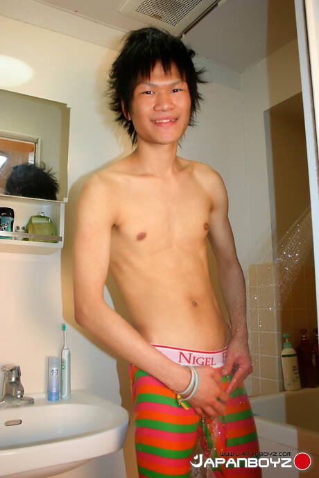 El jovencito oriental Masaru Sato se divierte con un juguete en el baño