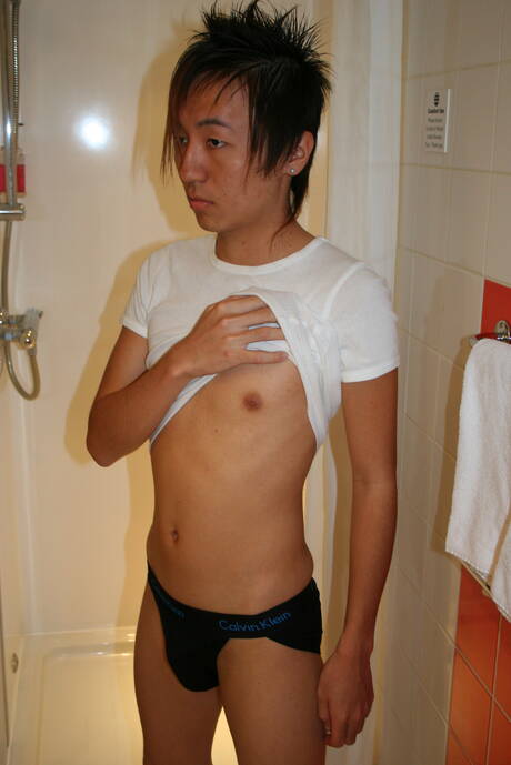 Der orientalische Junge Ryu spielt in der Dusche mit seinem Schwanz