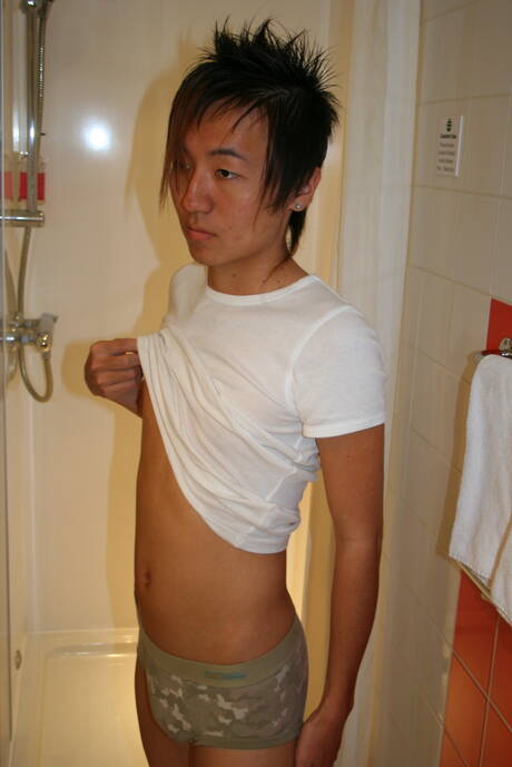 Der orientalische Junge Ryu spielt in der Dusche mit seinem Schwanz