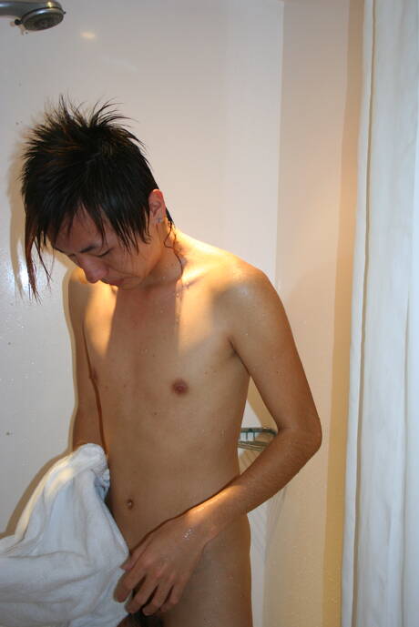 Der orientalische Junge Ryu spielt in der Dusche mit seinem Schwanz