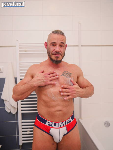 健美選手 Neil Henryk 在浴室中裸體擺造型，展現性感臀部