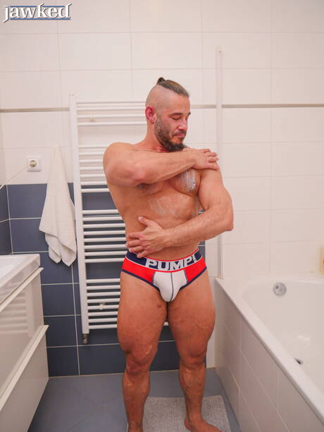 健美選手 Neil Henryk 在浴室中裸體擺造型，展現性感臀部