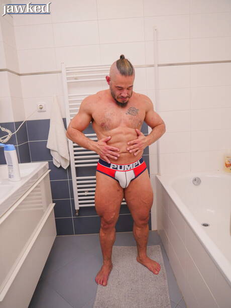 健美選手 Neil Henryk 在浴室中裸體擺造型，展現性感臀部