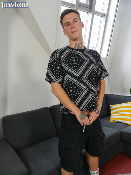 Der schöne Junge Kaleb Cross spielt mit dem Schwanz