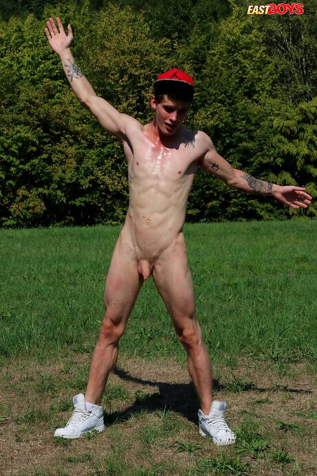 若いアレクサンダー・ドーチが服を脱いで、屋外でタイトなお尻を見せる