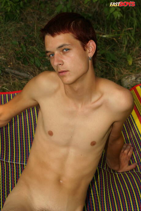 Młody chłopak Claiton pozuje nago i pokazuje ciasny tyłek na zewnątrz